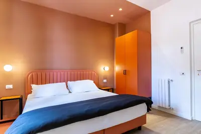 a bedroom with a large bed and orange walls at Luciano San Giovanni Guest House in Rome