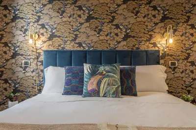 a bedroom with a bed with a blue headboard at Diana - Romantic Suite in Rome