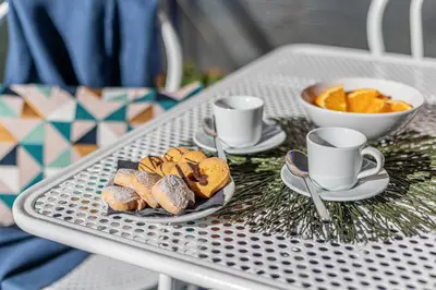 a tray with pastries and cups and a bowl of oranges at Diana - Romantic Suite in Rome