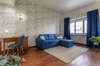a living room with a blue couch and a desk at Diana - Romantic Suite in Rome