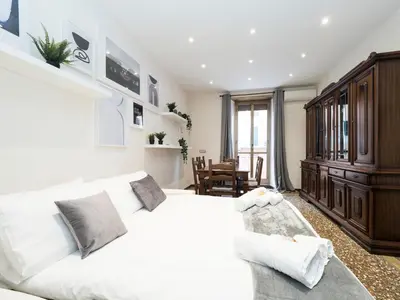 a bedroom with a white bed and a wooden cabinet at {Colosseum 10 minutes} Netflix & Free Wi-Fi in Rome