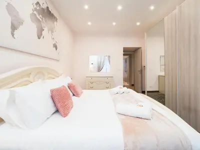 a white bedroom with a large white bed with two pillows at {Colosseum 10 minutes} Netflix & Free Wi-Fi in Rome