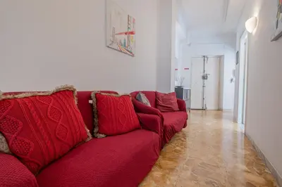 a red couch sitting in a living room at Basilica San Giovanni 1Bedr 5 minut from Station in Rome