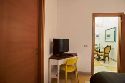 a bedroom with a desk with a television on it at Monteverde Suites in Rome