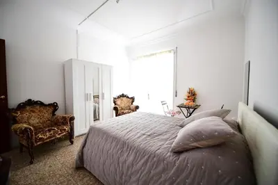 a bedroom with a bed and two chairs and a window at QUEEN VATICAN in Rome