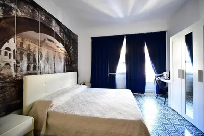 a bedroom with a large bed with a painting on the wall at QUEEN VATICAN in Rome