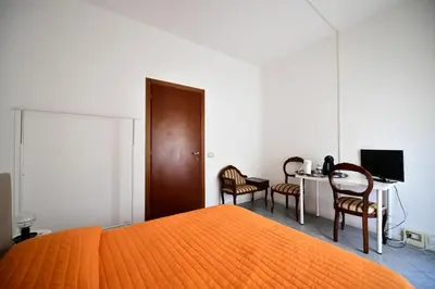 a bedroom with a bed and a desk with chairs at QUEEN VATICAN in Rome