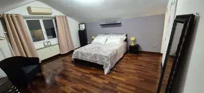 a bedroom with a bed and a chair on a wooden floor at Aroma Vaticano - Appartamento a San Pietro in Rome