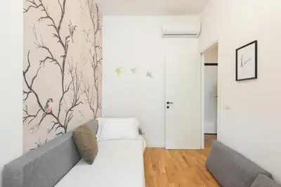 a living room with a couch and a wall at Ascanio's Cozy Apartment - by 101Flats in Rome