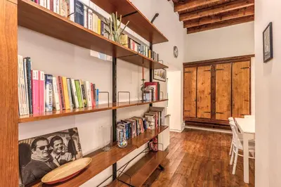 a room with wooden shelves filled with books at Trastevere Design & Comfort in Rome