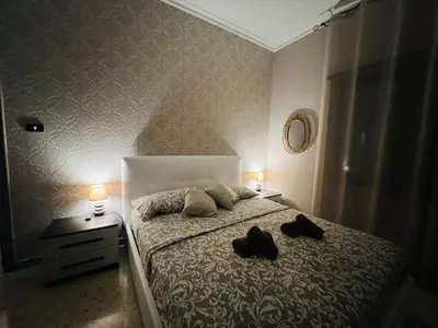 a bedroom with a bed with two black slippers on it at Apartment Albona 77 in Rome