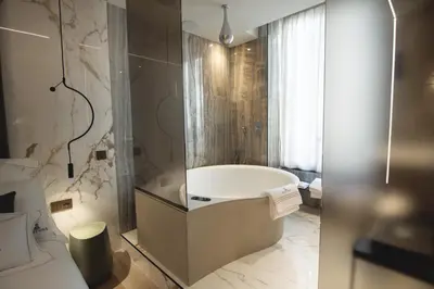a bathroom with a bath tub and a shower at Tritone Luxury Suites Fontana di Trevi in Rome