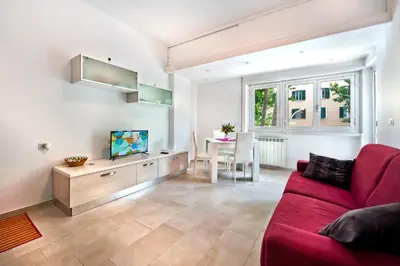 a living room with a red couch and a table at Appartamento Romantico a Trastevere in Rome