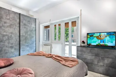 a bedroom with a large bed and a flat screen tv at Appartamento Romantico a Trastevere in Rome