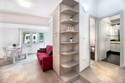 a living room with a red couch and a kitchen at Appartamento Romantico a Trastevere in Rome