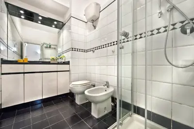 a white bathroom with a toilet and a sink at Appartamento Romantico a Trastevere in Rome
