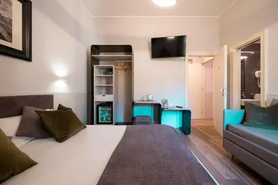 a bedroom with a large bed and a couch at Hotel de' Clementi in Rome