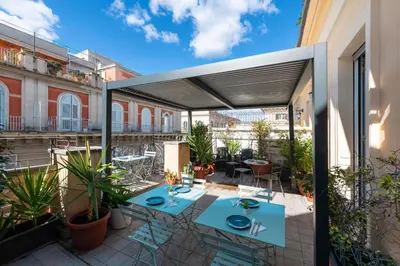 an outdoor patio with blue tables and chairs at Hotel de' Clementi in Rome