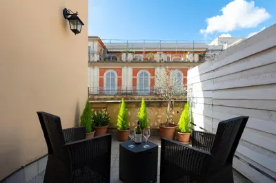 a balcony with two chairs and a table with plants at Hotel de' Clementi in Rome