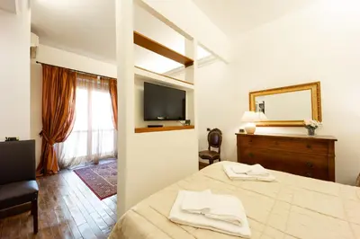 a bedroom with a bed with a mirror and a television at Altobelli Apartment in Rome