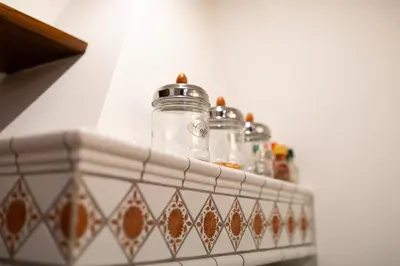 a shelf with glass jars on top of a wall at Altobelli Apartment in Rome