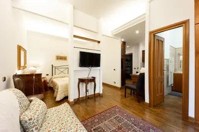 a living room with a couch and a bed and a television at Altobelli Apartment in Rome