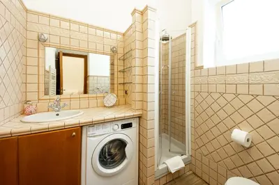 a bathroom with a washing machine and a sink at Altobelli Apartment in Rome