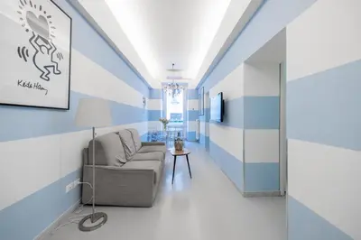a living room with blue and white walls and a couch at Vatican Apartment near Metro Ottaviano in Rome
