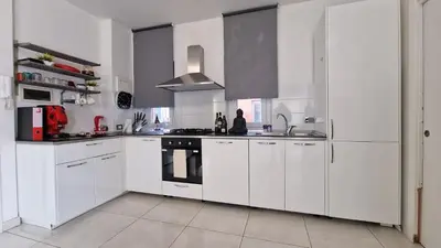 a white kitchen with white cabinets and a stove at LG colosseum Rome apartment in Rome