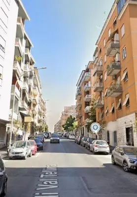 a city street with parked cars and buildings at Casina Valtellina in Rome