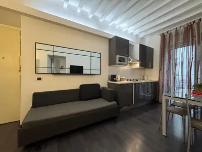 a living room with a couch and a kitchen at Minerva Apartment in Rome