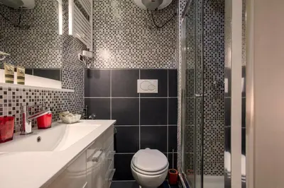 a bathroom with a shower and a toilet and a sink at Minerva Apartment in Rome