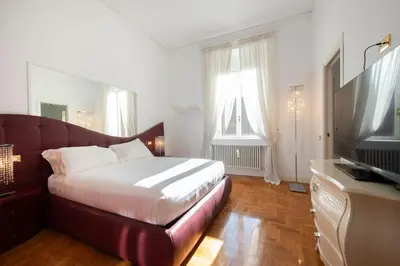 a bedroom with a bed and a flat screen tv at Lucrezio Caro Luxury Apartment in Rome