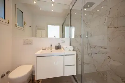 a white bathroom with a sink and a shower at Lucrezio Caro Luxury Apartment in Rome