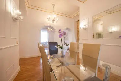 a dining room with a glass table and chairs at Lucrezio Caro Luxury Apartment in Rome