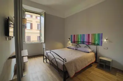 a bedroom with a bed with a rainbow painting on the wall at P88 guesthouse in Rome