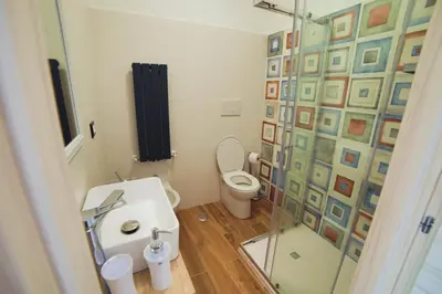 a bathroom with a toilet and a glass shower at P88 guesthouse in Rome