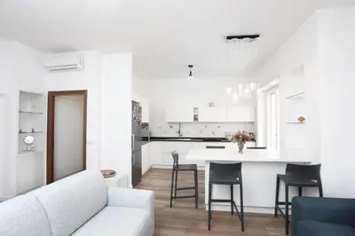 a white living room with a white couch and a kitchen at Bibi’s house Vaticano in Rome