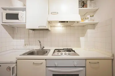 a white kitchen with a sink and a stove at Eri's Apartment in Rome