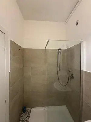 a bathroom with a shower with a glass door at Room Sapienza in Rome