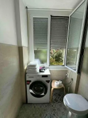 a washing machine in a bathroom with a toilet at Room Sapienza in Rome