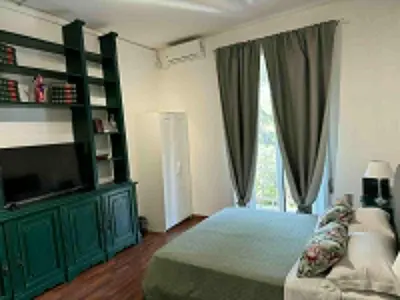 a bedroom with green furniture and a large window at Room Sapienza in Rome
