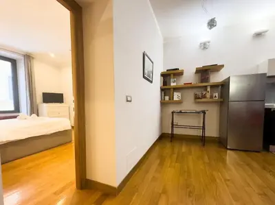 a kitchen with a refrigerator and a bed in a room at Maison Vittorio Borgo Pio in Rome