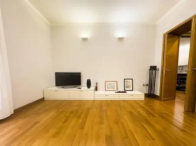 a white room with a television and a wooden floor at Maison Vittorio Borgo Pio in Rome