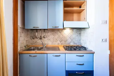 a kitchen with blue cabinets and a sink at Casa Nica in Rome