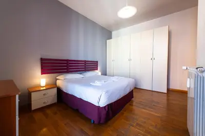 a bedroom with a large bed and a wooden floor at Casa Nica in Rome