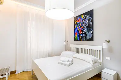 a white bedroom with a bed and a painting on the wall at Lion Aparts Rome in Rome