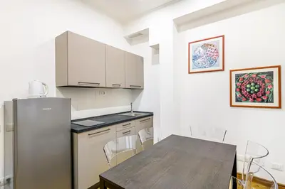a kitchen with a table and a refrigerator at Lion Aparts Rome in Rome