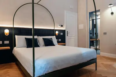 a bedroom with a large bed with a metal canopy at The Flow - Via Del Corso in Rome