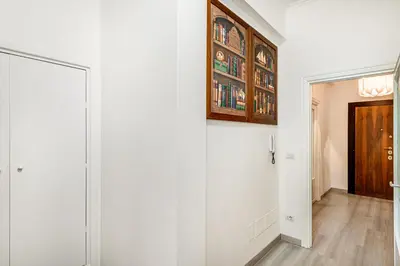 a hallway with a white wall and a door at Lion Aparts Rome - Vatican City in Rome